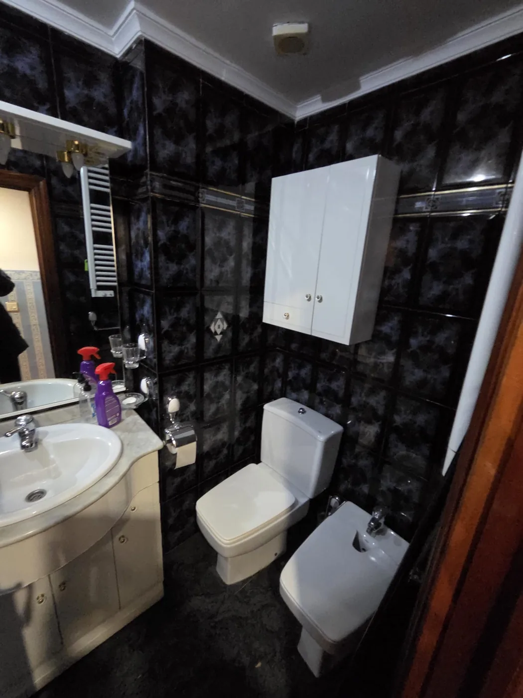 Baño principal antes de la reforma en Santutxu, con alicatado oscuro